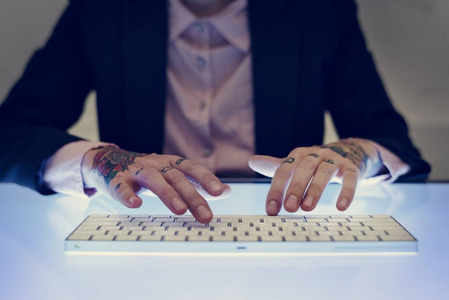 在键盘上键入纹身的手