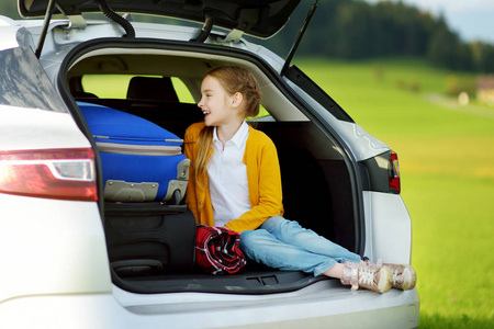 可爱的小女孩准备和她的父母去度假。在旅途中, 孩子在车里放松。开车和孩子们一起旅行