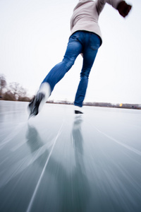 在一个池塘上户外滑冰的年轻女子冰