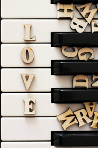 钢琴钥匙特写与信件爱和心脏。与情人节的原创艺术形象
