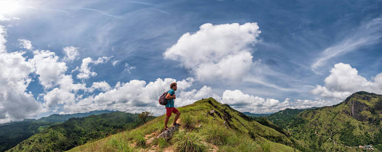 白种人徒步旅行者用背包在山顶休息