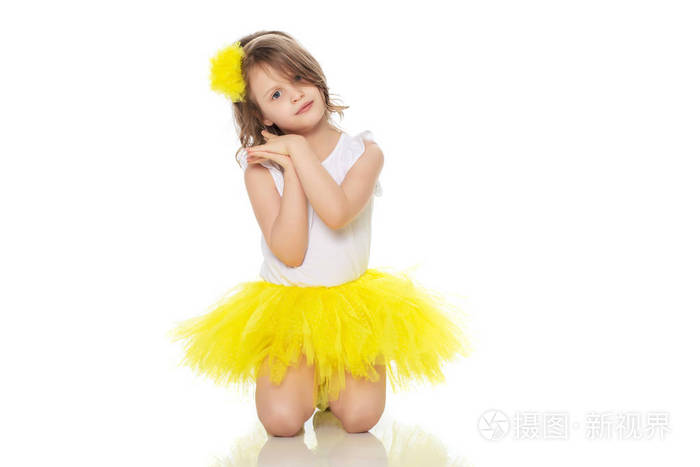 在一条黄裙子和白色 t 恤的小女孩