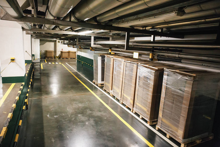 工业仓库或后勤机库内部。走廊里的箱子和管道