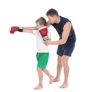 可爱的小男孩训练与拳击教练在白色背景