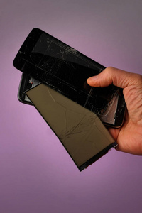 破碎的黑色移动智能手机与破获显示躺在他的手, 在丁香的背景, 前视图