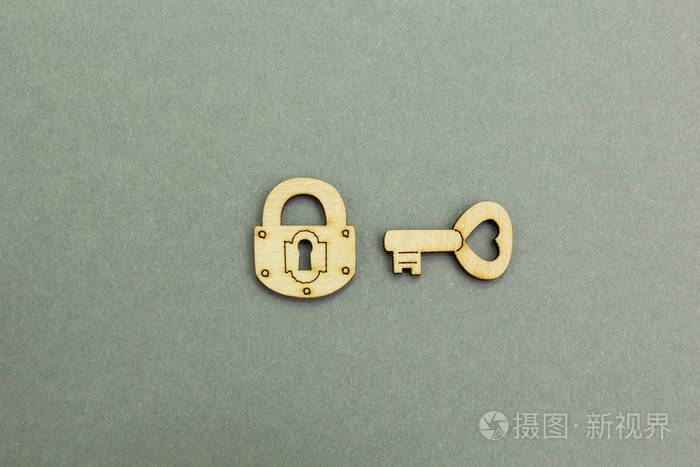 灰色背景下的木锁和钥匙