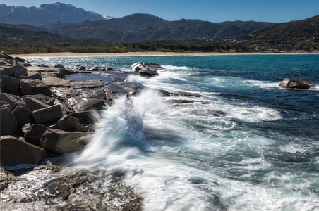 在科西嘉阿尔加约拉海滩附近的岩石上波浪撞击