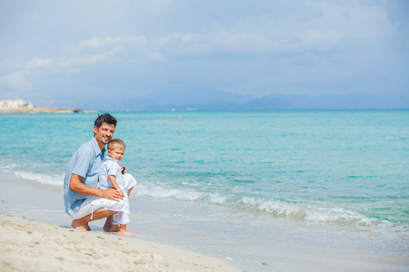 快乐的父亲和他的儿子在海滩上玩