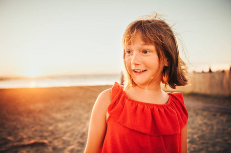 关在肖像的可爱的小女孩以短 bob 发型在日落时分在海边休息