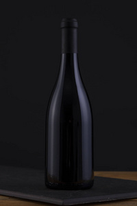 黑色木质背景和黑色标签的孤立红酒瓶