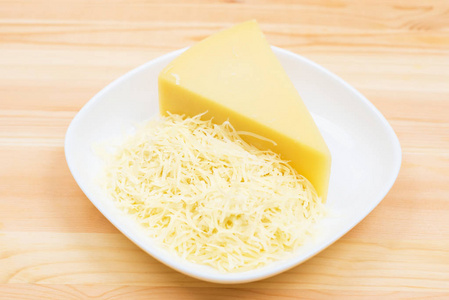 在盘子里的木桌上的特写是用磨碎的砖块做成的干酪。固体乳制品的概念