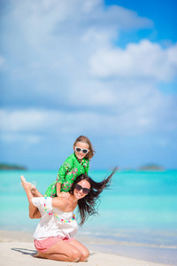 美丽的母亲和女儿在加勒比海滩享受暑假