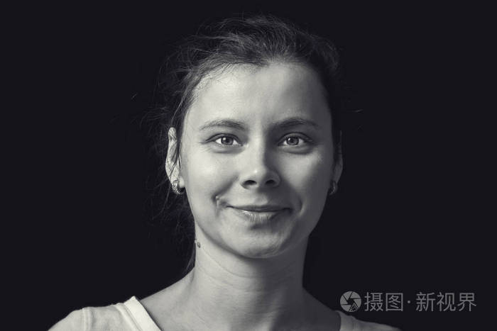 黑色背景下的年轻女子的黑白肖像.自然的人脸与现实的