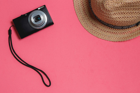 旅行者假期配件 相片照相机, 褐色帽子, 在粉红色背景。Copyspace 旅游概念