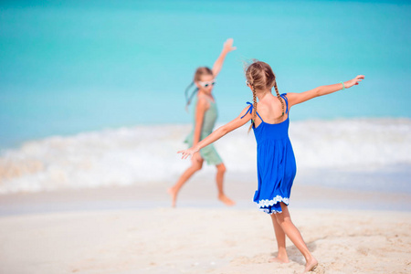 两个小快乐的女孩在热带海滩玩得很开心