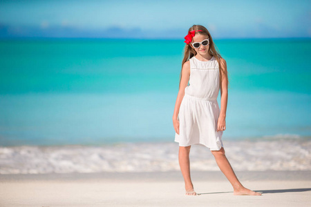 美丽的小女孩在白色礼服在海滩乐趣