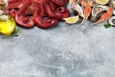 海鲜.章鱼, 牡蛎, 龙虾, 虾, 蛤蜊烹饪。带空格的石桌上的顶部视图