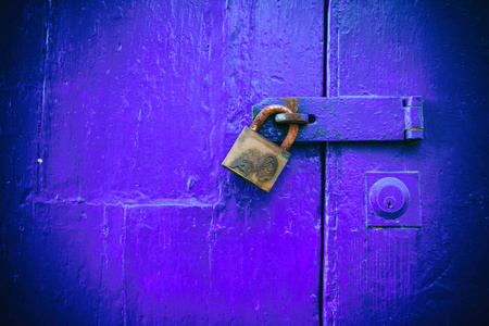 上锁的门。旧的蓝色木门封闭旧生锈的挂锁