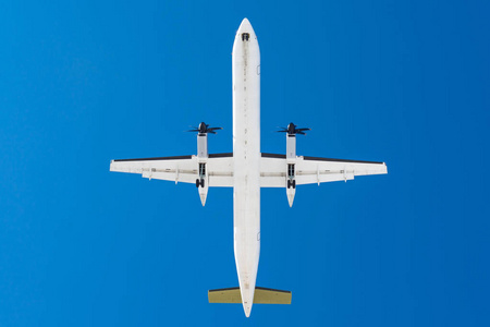 涡轮螺旋桨发动机在飞机上的机翼上降落在机场跑道上对蓝天