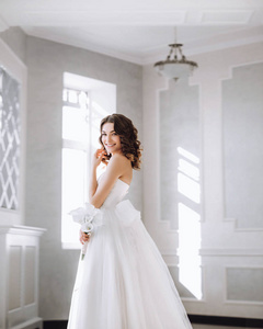 美丽的新娘与花束在白色大厅里