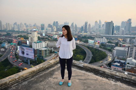 roofto 在日落时分看曼谷城市的亚洲商界女性