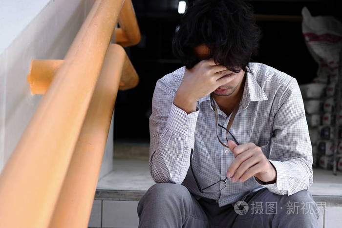失意的年轻亚洲男人抚摸着头 感到失望或疲惫.失业的生意人概念