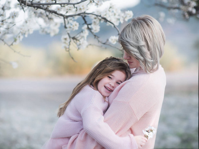 母亲和女儿的肖像温柔地拥抱在花园开花 almendra