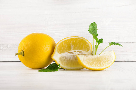 新鲜成熟的柠檬, 切片, 质朴的食物摄影在白色木盘子厨房桌可以作为背景