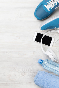健身概念背景与运动鞋, 耳机, 水瓶和毛巾。具有文本空间的顶部视图