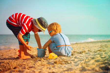小男孩和女孩在沙滩上玩沙