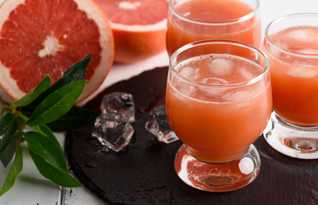 葡萄柚汁和木制的背景上成熟葡萄柚