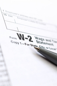 钢笔在 W2 工资和纳税申报表上。纳税时间