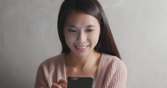 女人看着智能手机和微笑