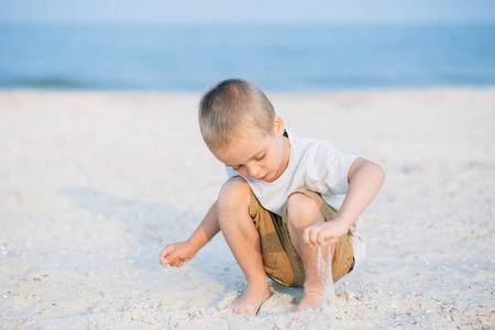 画像严重的小男孩在沙滩上玩耍, 大海。积极的人的情绪, 感觉, 快乐。有趣的可爱的孩子度假和享受夏天