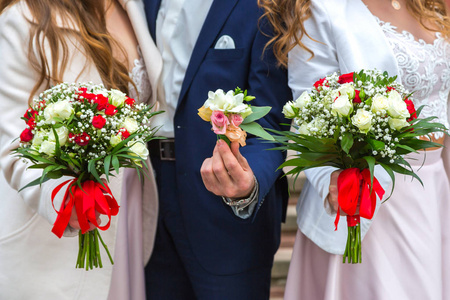 新娘和两个新娘举行婚礼花束, 显示他们