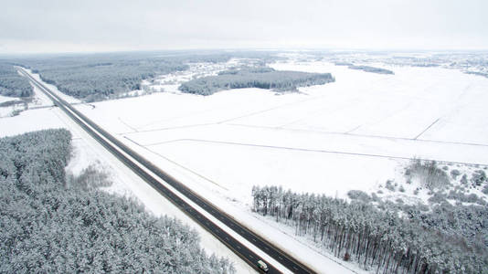 冬天的森林和道路。视图。照片是用无人驾驶飞机拍摄的。雪中的松树和冷杉林