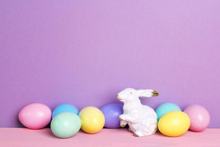 彩色复活节彩蛋与兔子在紫色背景