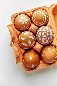 在五颜六色的橙色纸板容器, 复活节假日概念的各种各样的白色样式被绘的蛋