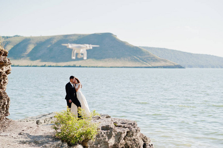 婚礼情侣在惊险的风景与岩石和湖