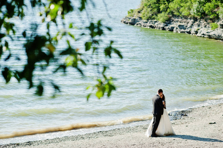 婚礼情侣在惊险的风景与岩石和湖