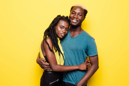 一个可爱的年轻美国黑人情侣的肖像拥抱在黄色隔离