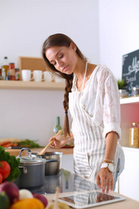 厨房里用木勺做饭的女人。烹调妇女