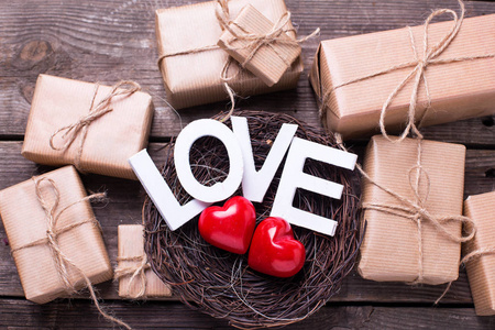 词爱, 盒与礼物和二心脏在装饰的巢在古董木背景。选择性聚焦