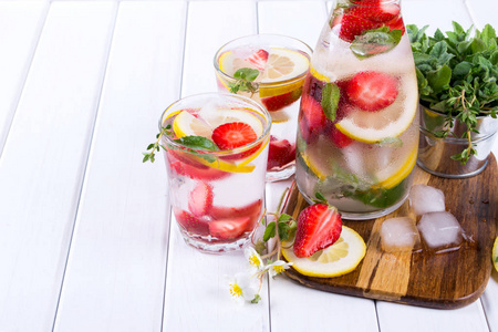 冷新鲜的自制柠檬水用草莓和香草。排毒苏打水配方