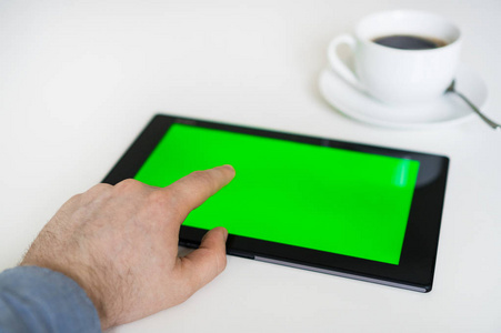 手触触摸平板电脑与绿色屏幕。色度键
