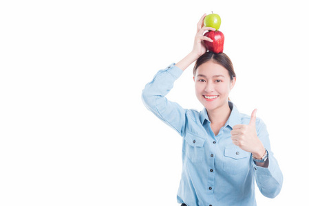 女人把苹果头上, 并显示拇指