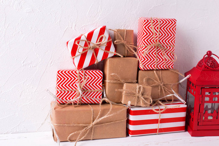 包装五颜六色的礼品盒与礼物和装饰灯笼在白色纹理背景。选择性聚焦