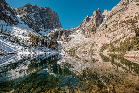 翡翠湖与岩石和山在周围的雪在秋天思考。在美国科罗拉多州的落基山国家公园