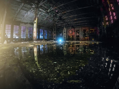 大型空弃仓库大楼或工厂车间夜间用水反射, 抽象废墟背景