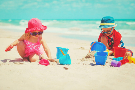 快乐的小男孩和女孩在沙滩上玩沙